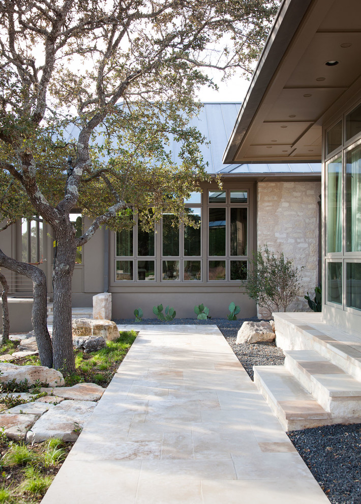 Idée de décoration pour un jardin arrière design avec des pavés en pierre naturelle.