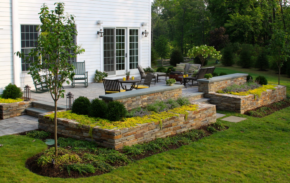 This is an example of a mid-sized traditional partial sun backyard concrete paver landscaping in New York for summer.