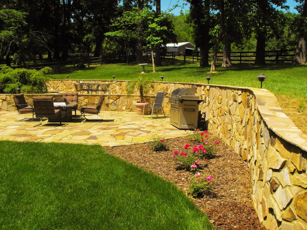 Foto di un giardino formale esposto a mezz'ombra di medie dimensioni e dietro casa in estate con un muro di contenimento e pavimentazioni in pietra naturale