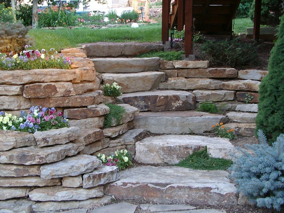 Idée de décoration pour un grand jardin arrière tradition avec une exposition ombragée, des pavés en pierre naturelle et un mur de soutènement.