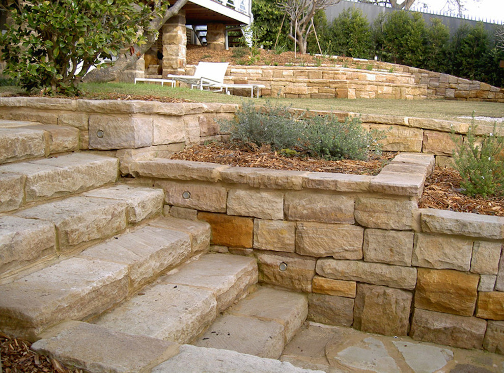 Photo of a large classic back fully shaded garden in New York with natural stone paving and a retaining wall.