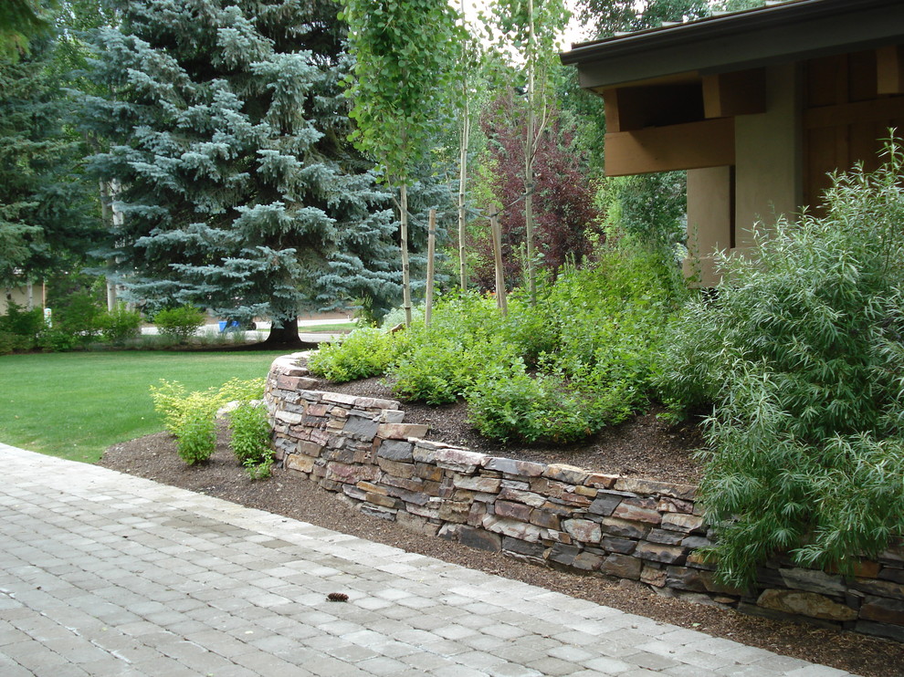 Inspiration for a mid-sized traditional partial sun backyard stone landscaping in Boise for spring.
