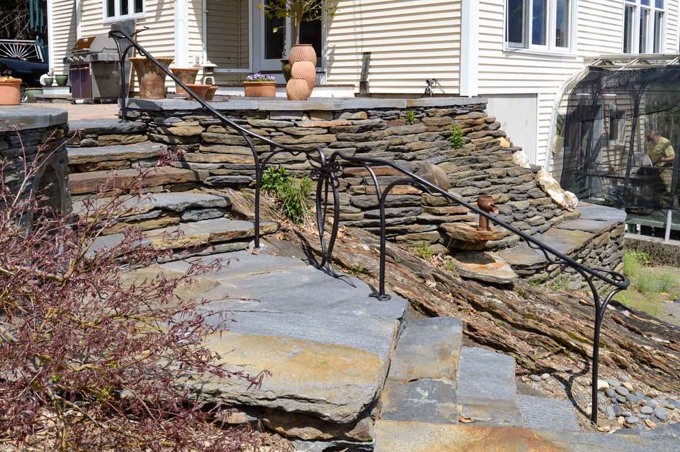 Inspiration for a mid-sized rustic partial sun backyard stone landscaping in Boston.