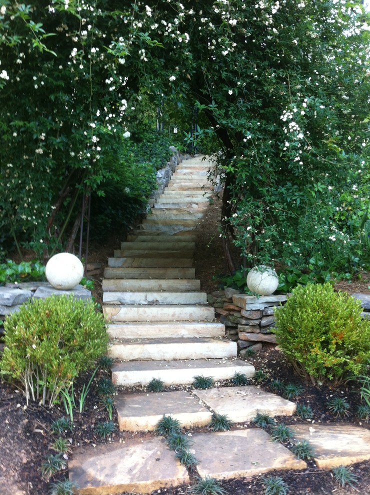 Idée de décoration pour un grand jardin arrière design avec des pavés en pierre naturelle.
