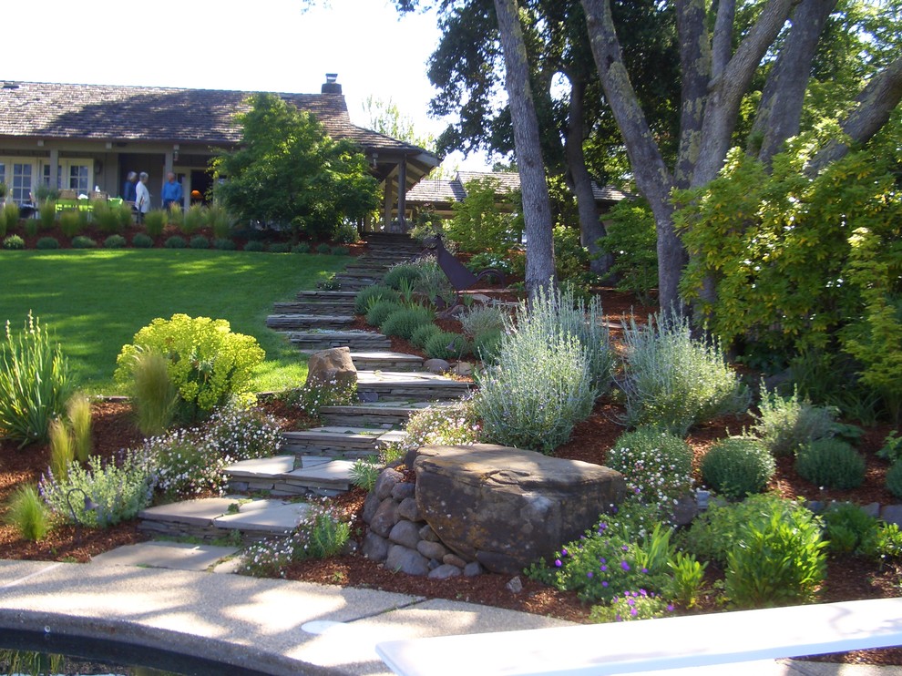 Idée de décoration pour un jardin tradition avec une pente, une colline ou un talus et des pavés en pierre naturelle.