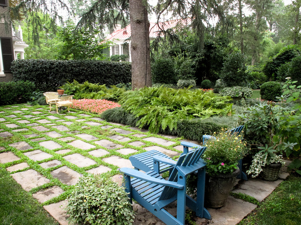 This is an example of an expansive classic back fully shaded garden in Louisville with gravel and an outdoor sport court.
