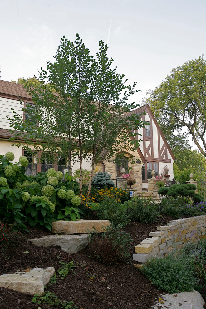 Esempio di un giardino rustico di medie dimensioni e davanti casa con un muro di contenimento e pavimentazioni in cemento