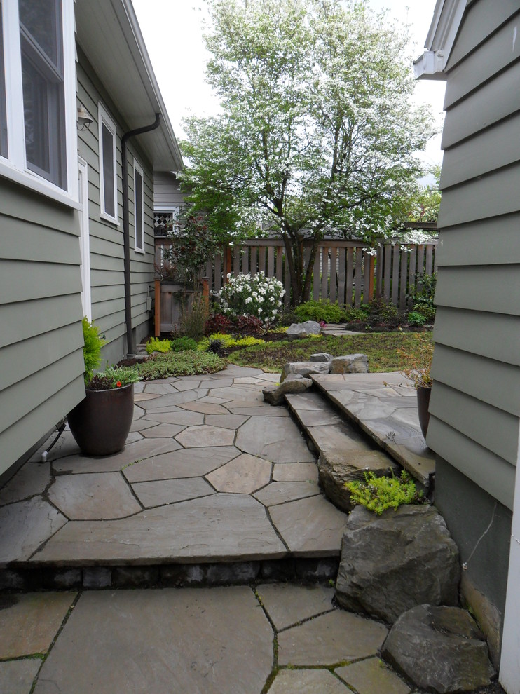 Foto di un piccolo giardino american style esposto a mezz'ombra dietro casa in primavera con un ingresso o sentiero e pavimentazioni in pietra naturale