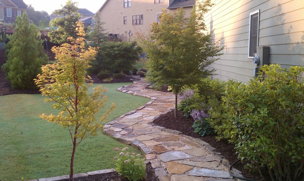 Design ideas for a large traditional partial sun side yard stone landscaping in Atlanta.