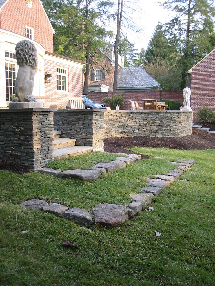 Klassische Gartenmauer hinter dem Haus mit direkter Sonneneinstrahlung und Mulch in Baltimore