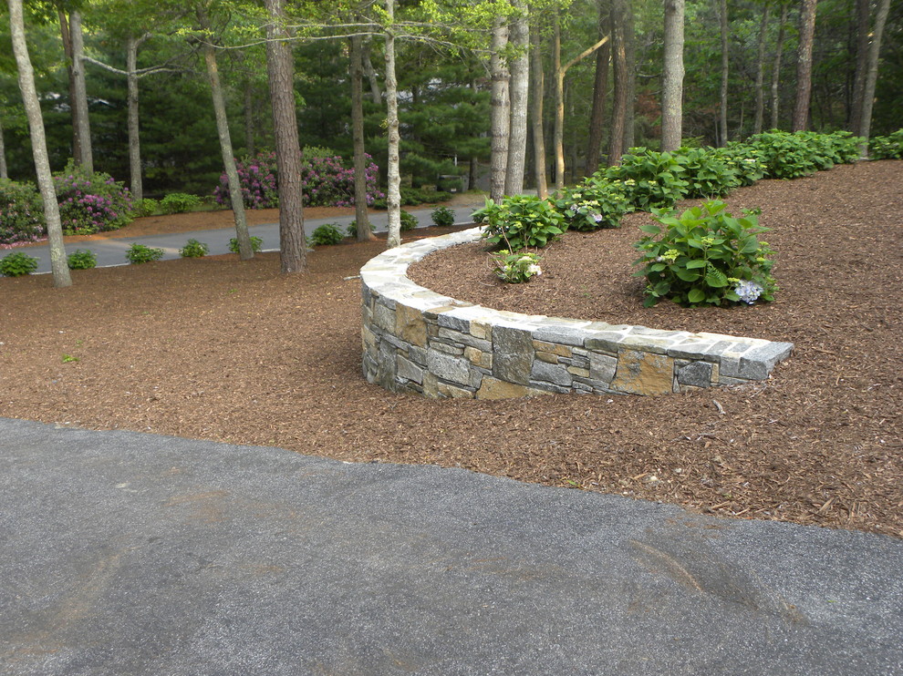 Design ideas for a mid-sized traditional partial sun backyard mulch retaining wall landscape in Boston.