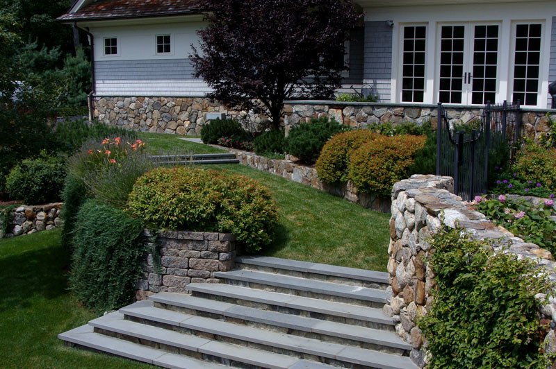 Inspiration pour un jardin à la française arrière traditionnel de taille moyenne avec un mur de soutènement et des pavés en pierre naturelle.