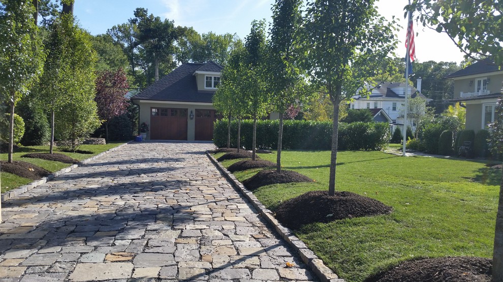 Immagine di un grande giardino american style esposto a mezz'ombra davanti casa con un ingresso o sentiero e pavimentazioni in pietra naturale