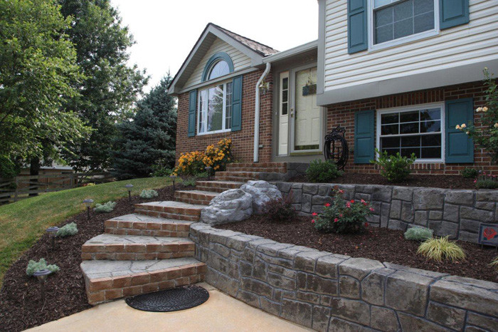 This is an example of a mid-sized partial sun front yard stone retaining wall landscape in Baltimore for fall.