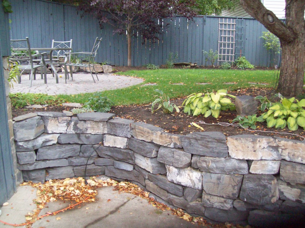 Diseño de jardín contemporáneo de tamaño medio en patio trasero con muro de contención y adoquines de piedra natural