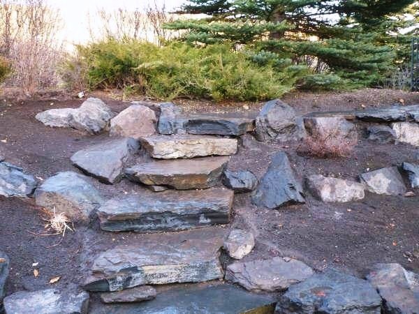 Inspiration for a mid-sized contemporary hillside stone garden path in Calgary.