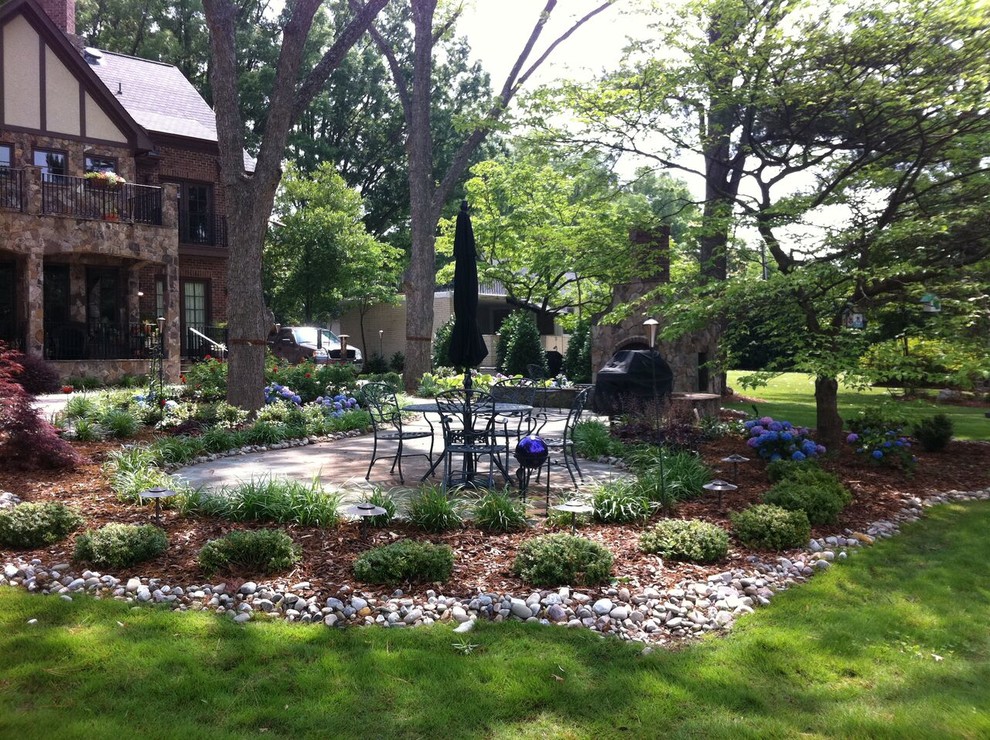 Immagine di un grande giardino classico esposto a mezz'ombra dietro casa con un caminetto e pavimentazioni in pietra naturale