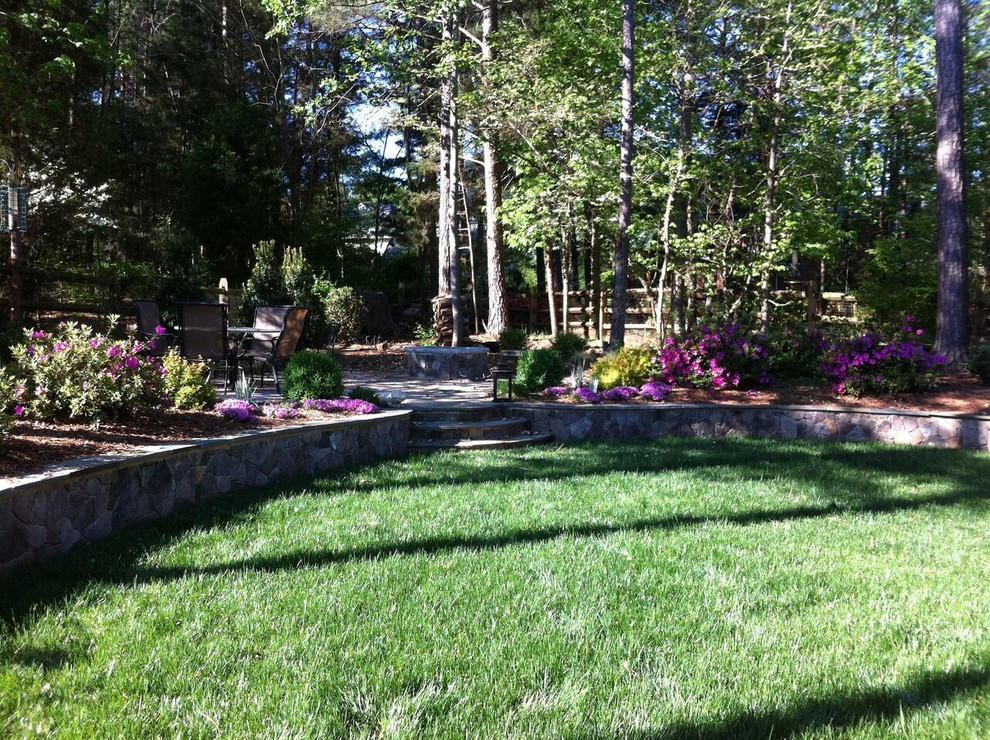 Design ideas for a large transitional partial sun backyard stone landscaping in Charlotte with a fire pit.