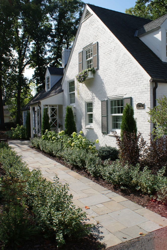Пример оригинального дизайна: солнечный участок и сад среднего размера на переднем дворе в классическом стиле с садовой дорожкой или калиткой, хорошей освещенностью и покрытием из каменной брусчатки