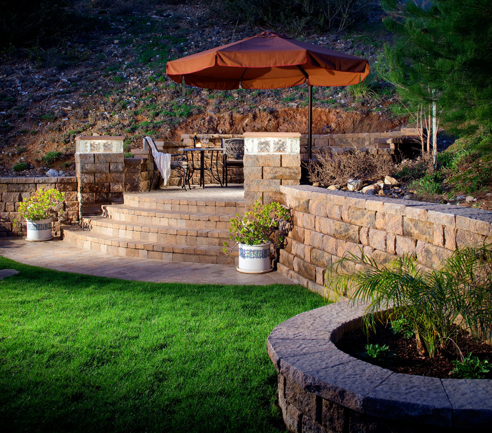 This is an example of a medium sized back garden in San Diego with a retaining wall and concrete paving.