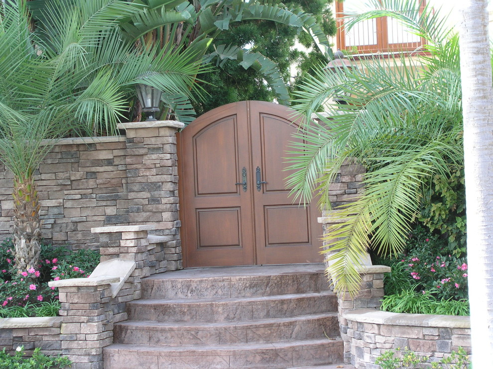 This is an example of a mid-sized tropical front yard stone landscaping in Los Angeles.