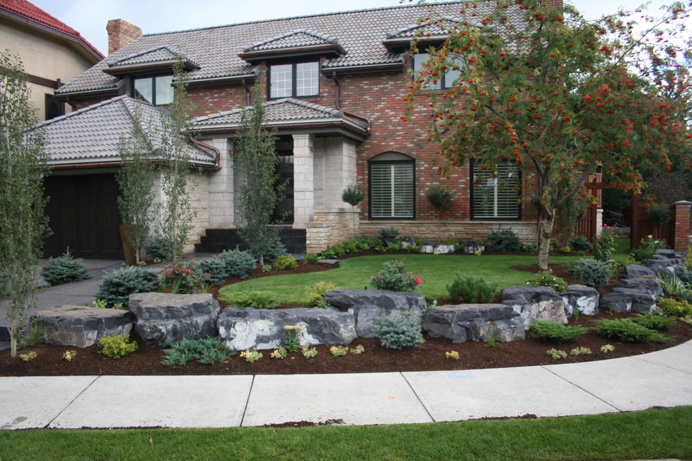 Photo of a medium sized modern front garden in Calgary with a garden path and natural stone paving.