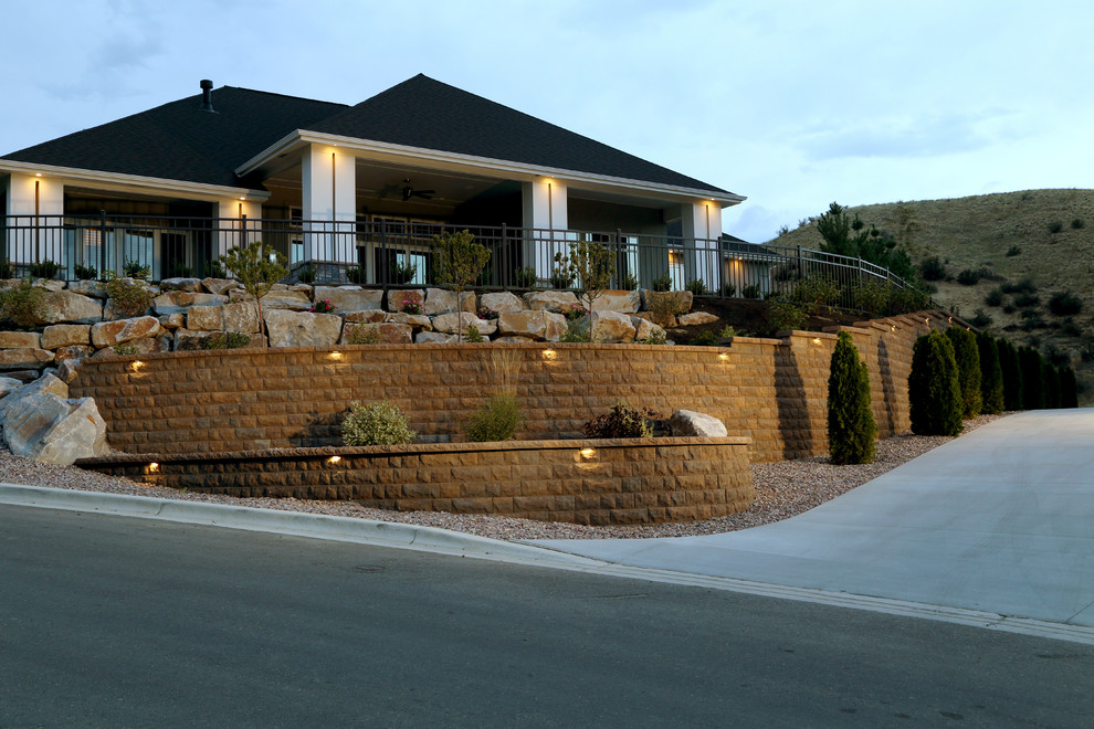 Design ideas for a large front driveway full sun garden for summer in Boise with a retaining wall and concrete paving.