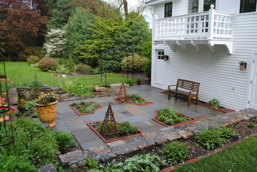 Ejemplo de jardín clásico renovado en patio trasero con adoquines de piedra natural