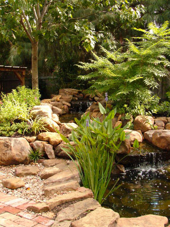 Ispirazione per un laghetto da giardino tradizionale di medie dimensioni e dietro casa con pavimentazioni in pietra naturale