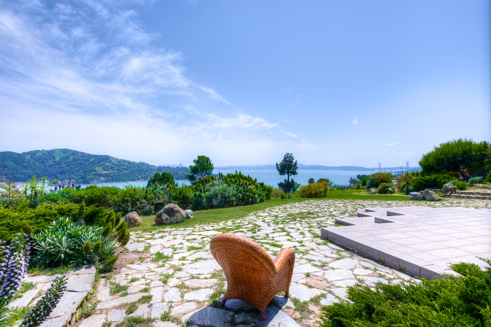 Immagine di un grande giardino mediterraneo esposto in pieno sole dietro casa con pavimentazioni in pietra naturale