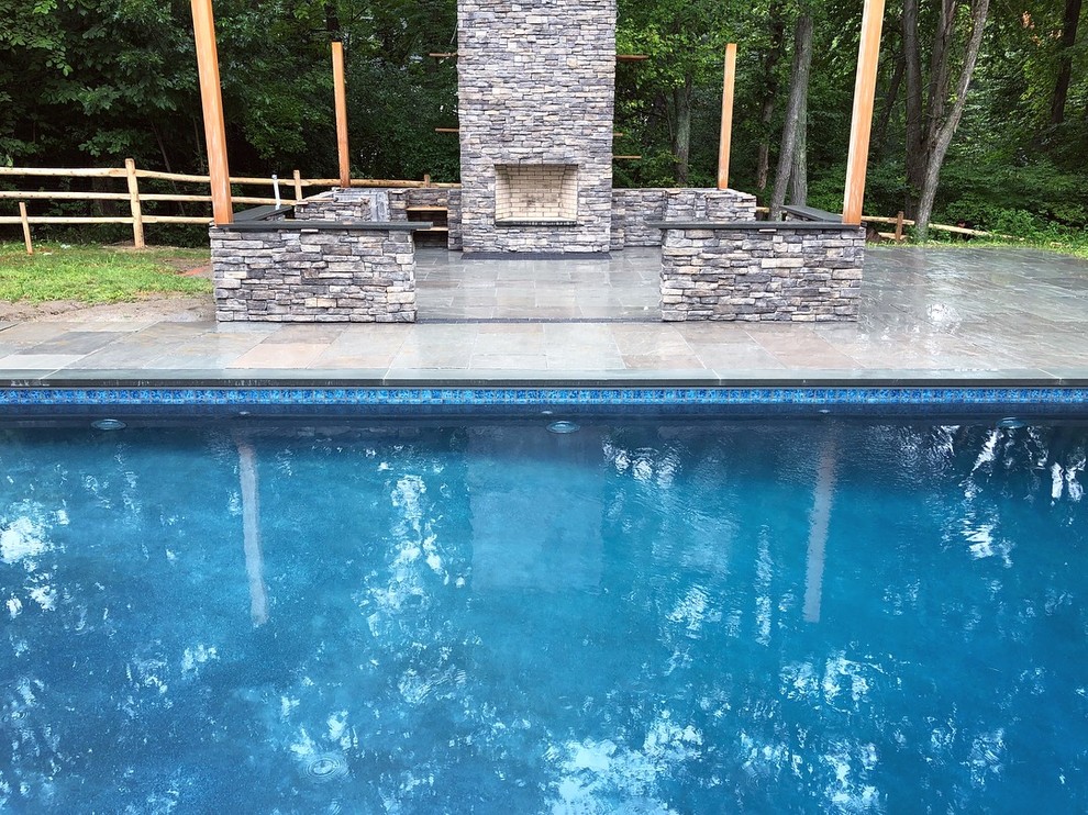 Inspiration for a contemporary partial sun backyard stone landscaping in New York with a fireplace for summer.