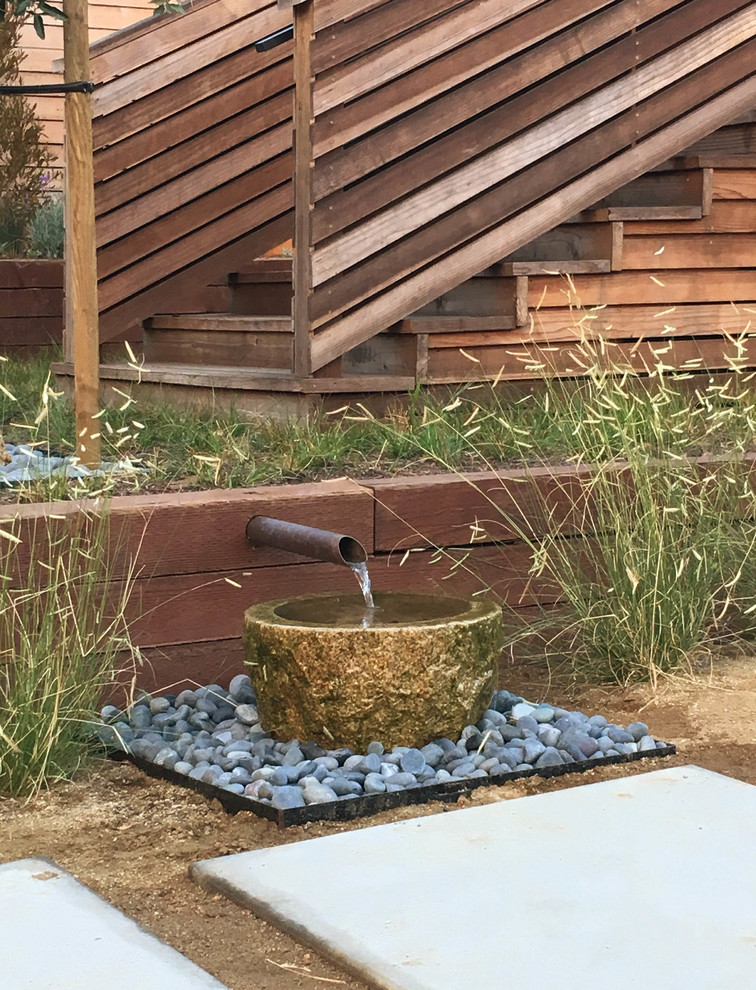 Photo of a mid-sized modern drought-tolerant and full sun backyard concrete paver water fountain landscape in Los Angeles for spring.