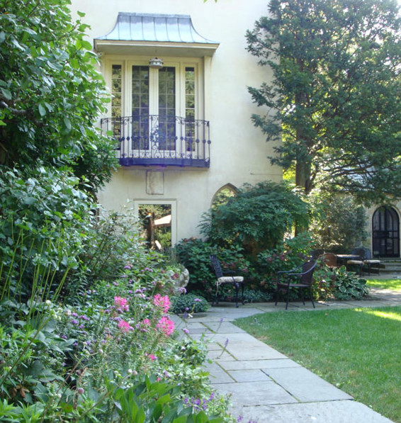 Aménagement d'un jardin arrière classique de taille moyenne avec une exposition ensoleillée et des pavés en pierre naturelle.