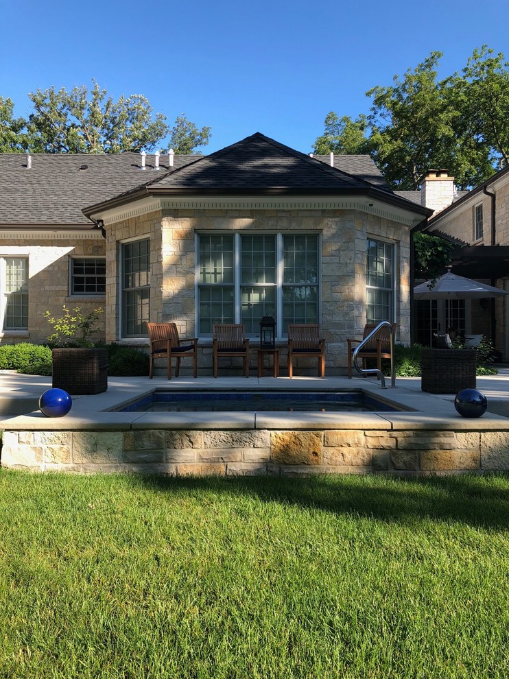 This is an example of an expansive traditional back partial sun garden in Chicago with natural stone paving.