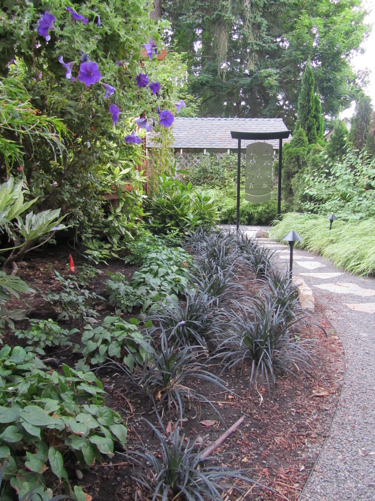 На фото: солнечный участок и сад среднего размера на заднем дворе в восточном стиле с подпорной стенкой, хорошей освещенностью и покрытием из гравия
