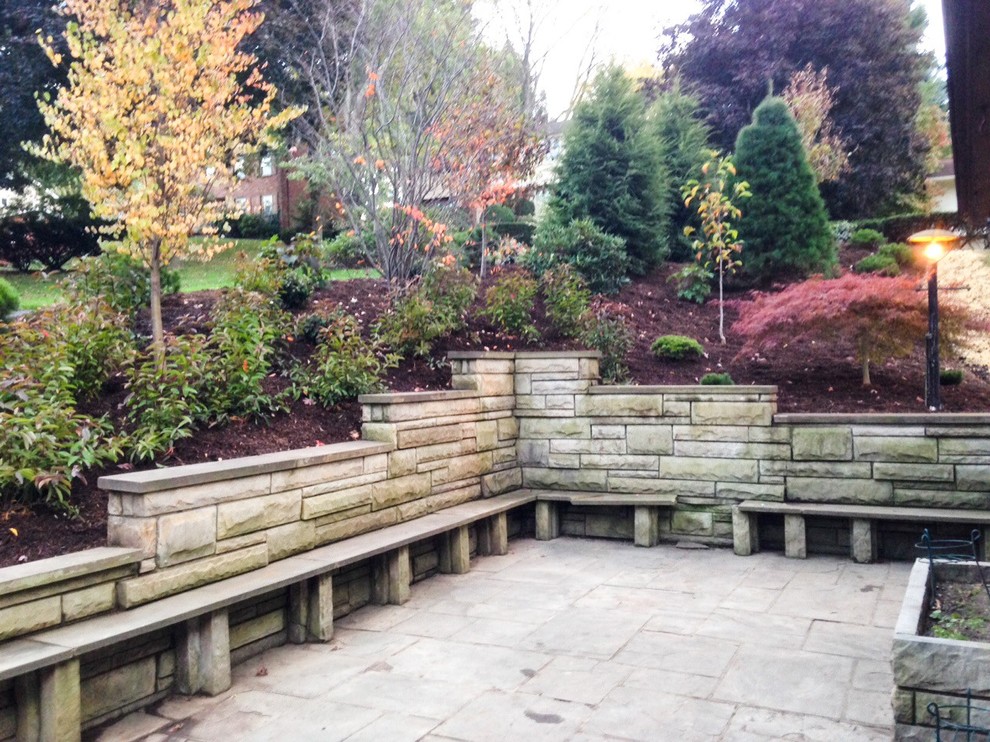 Aménagement d'un très grand jardin latéral craftsman l'automne avec un mur de soutènement, une exposition ensoleillée et des pavés en pierre naturelle.