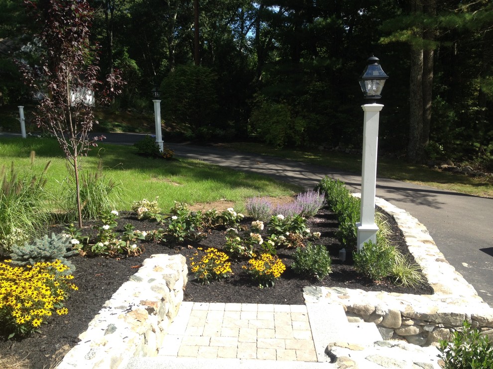 Идея дизайна: солнечный регулярный сад среднего размера на переднем дворе в классическом стиле с подпорной стенкой, хорошей освещенностью и покрытием из каменной брусчатки