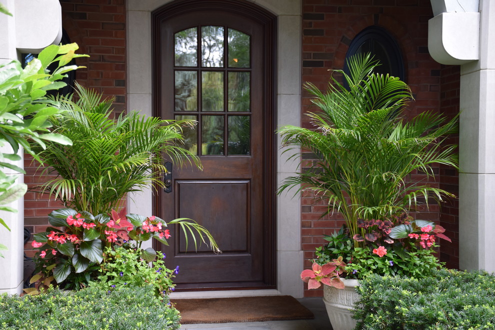 This is an example of a classic front formal partial sun garden for summer in Chicago with a potted garden.