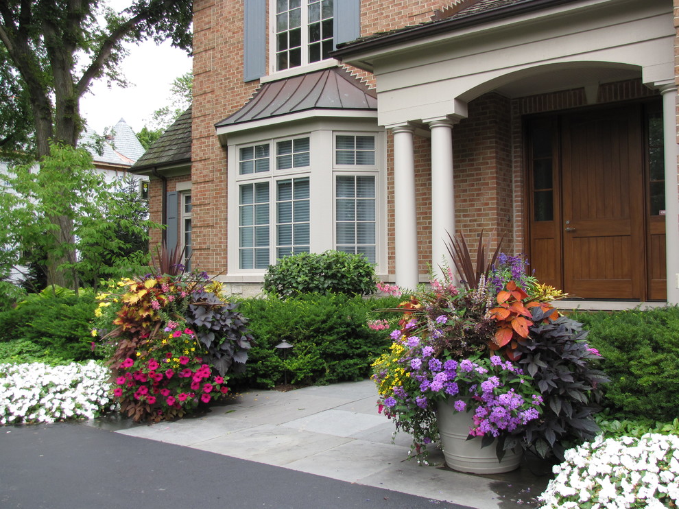Inspiration for a large traditional full sun front yard stone landscaping in Chicago for summer.
