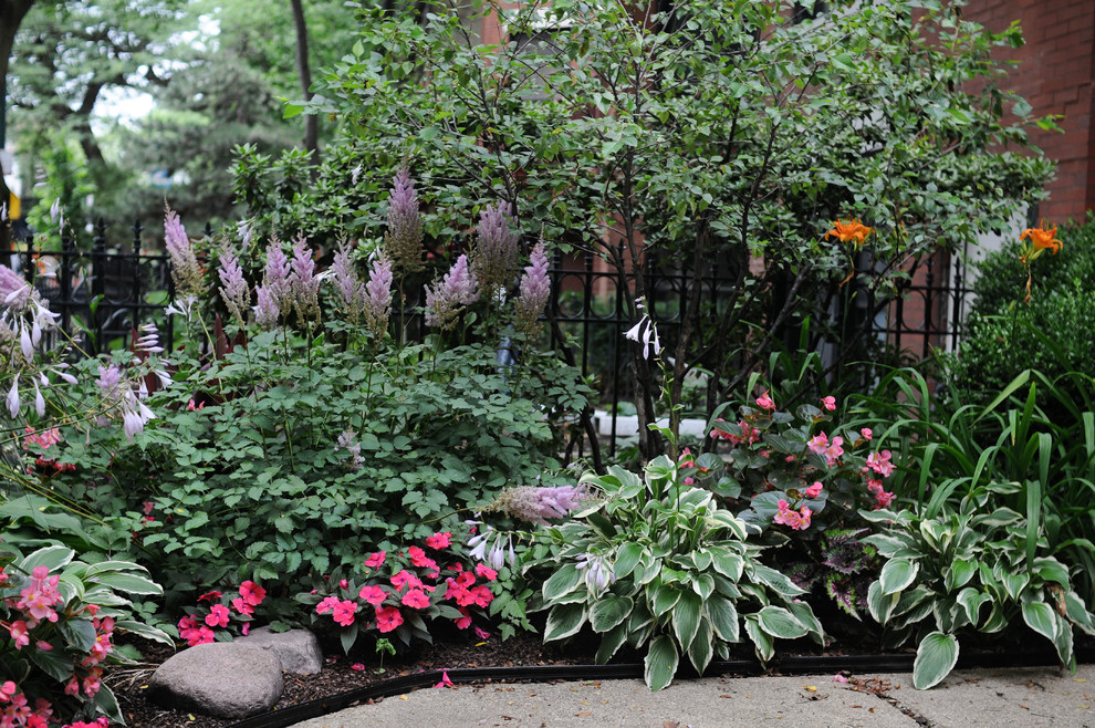 This is an example of a mid-sized transitional partial sun backyard concrete paver formal garden in Chicago for summer.