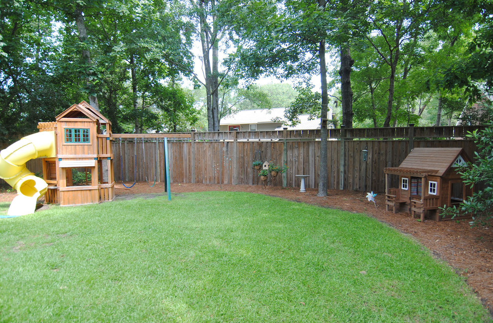 This is an example of a large classic back full sun garden for summer in Other with a climbing frame and mulch.