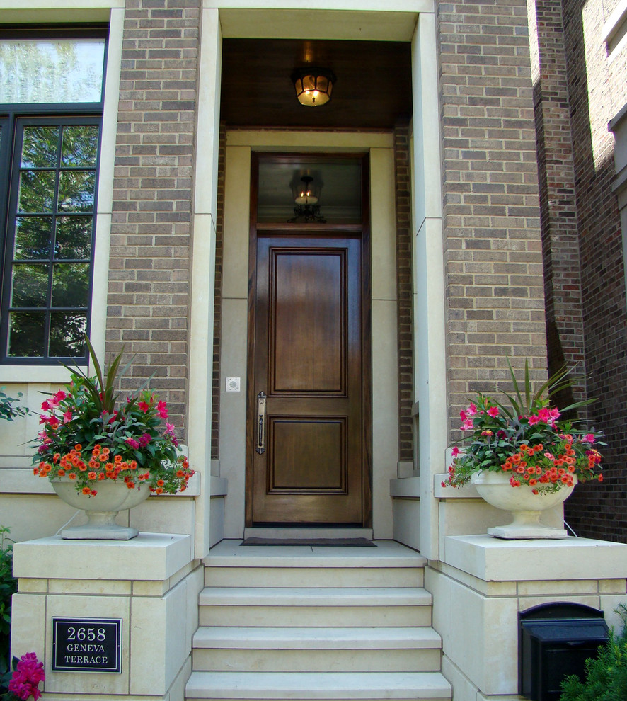 This is an example of a mid-sized traditional partial sun front yard stone landscaping in Chicago for summer.