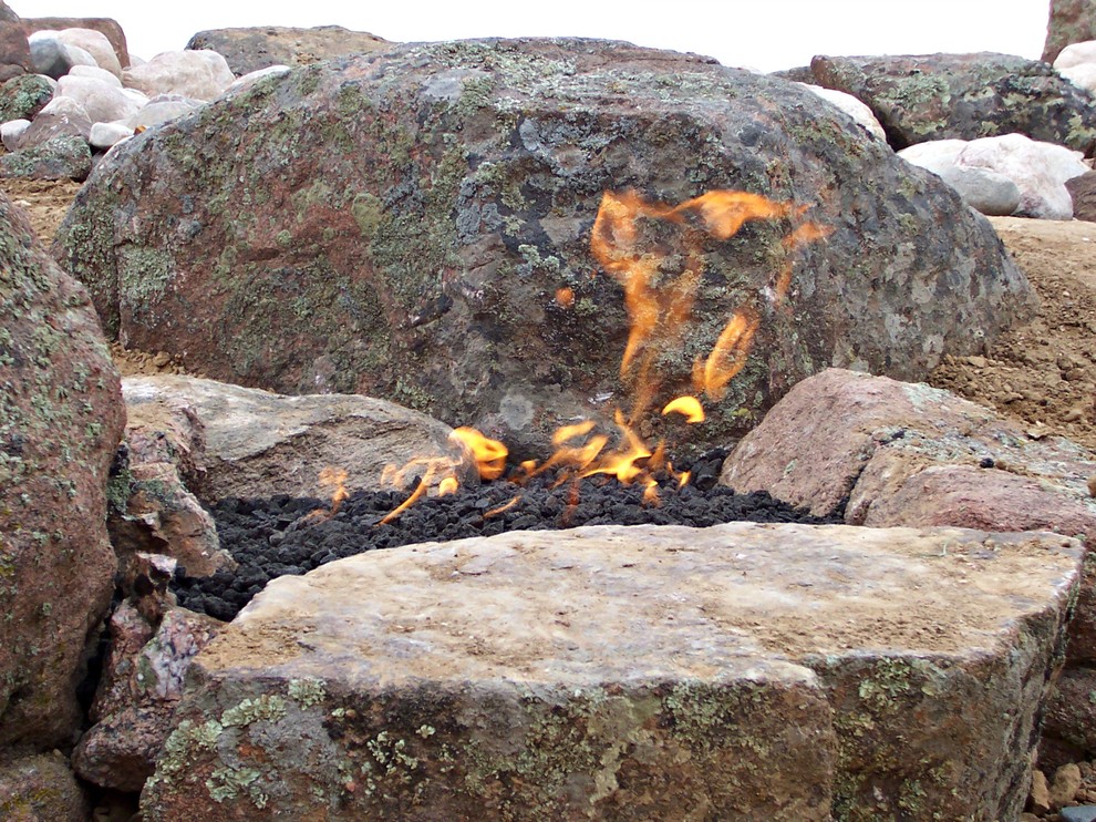 Inspiration for a traditional backyard stone landscaping in Denver with a fire pit.