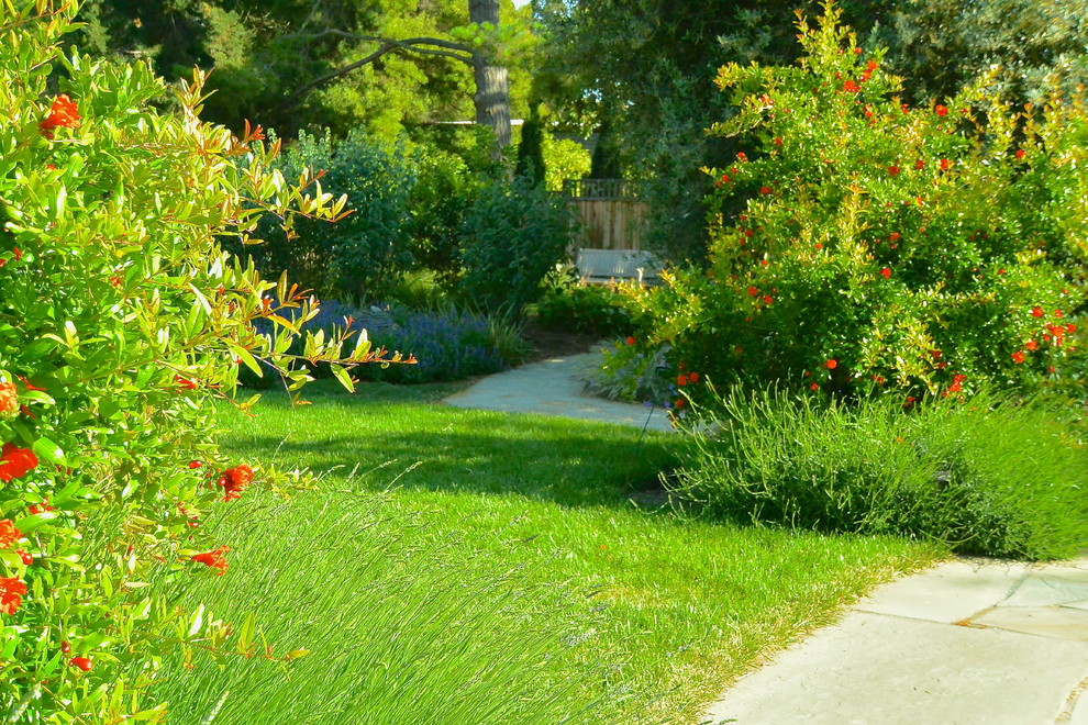 Idéer för en stor medelhavsstil bakgård i delvis sol på våren, med en trädgårdsgång och grus