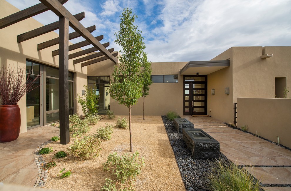 Design ideas for a medium sized front xeriscape full sun garden in Albuquerque with gravel.