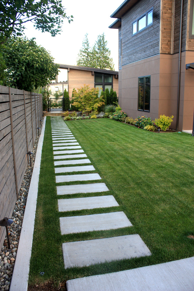 Immagine di un giardino formale minimal esposto in pieno sole di medie dimensioni e davanti casa con un ingresso o sentiero e pavimentazioni in cemento