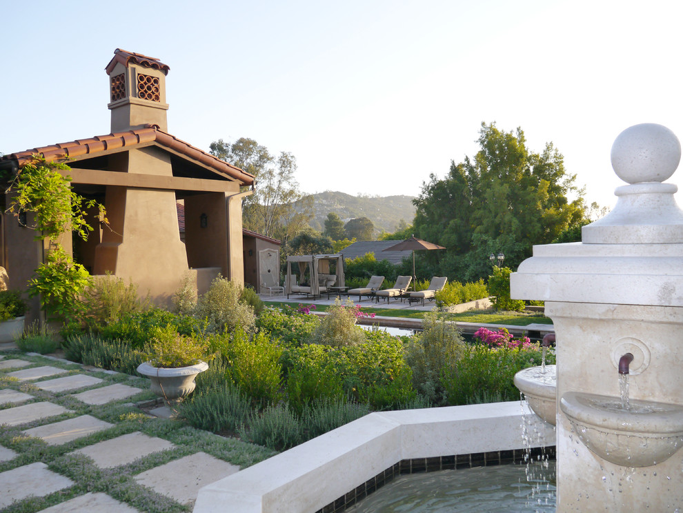 Свежая идея для дизайна: садовый фонтан на заднем дворе в средиземноморском стиле с покрытием из каменной брусчатки - отличное фото интерьера