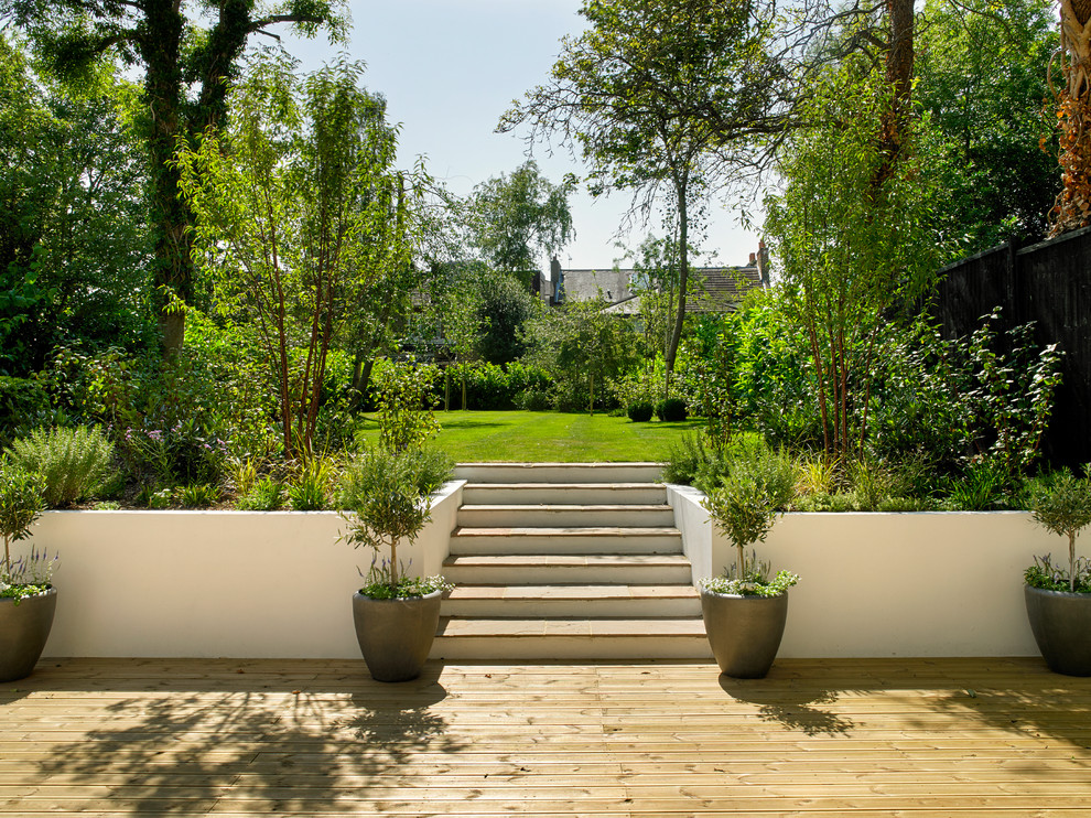 Aménagement d'un jardin classique avec une terrasse en bois.