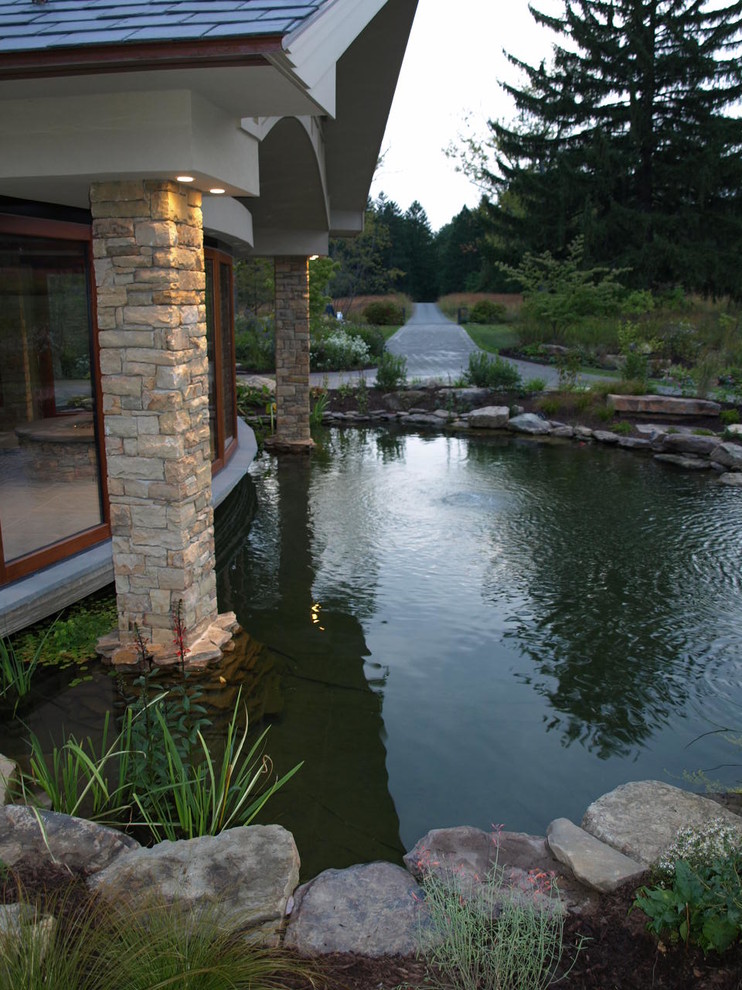 Photo of a large classic front full sun garden for summer in Philadelphia with a water feature and natural stone paving.