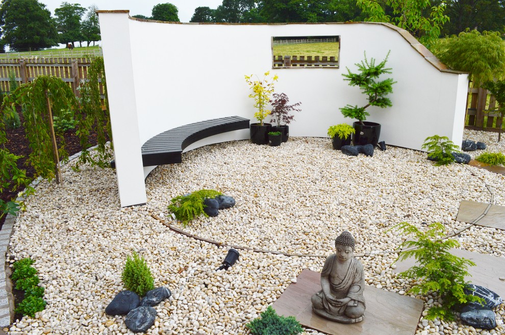 Foto di un giardino formale etnico esposto a mezz'ombra con ghiaia